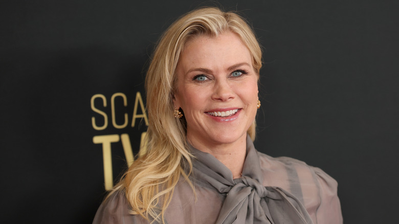 Alison Sweeney sonriendo con un top gris