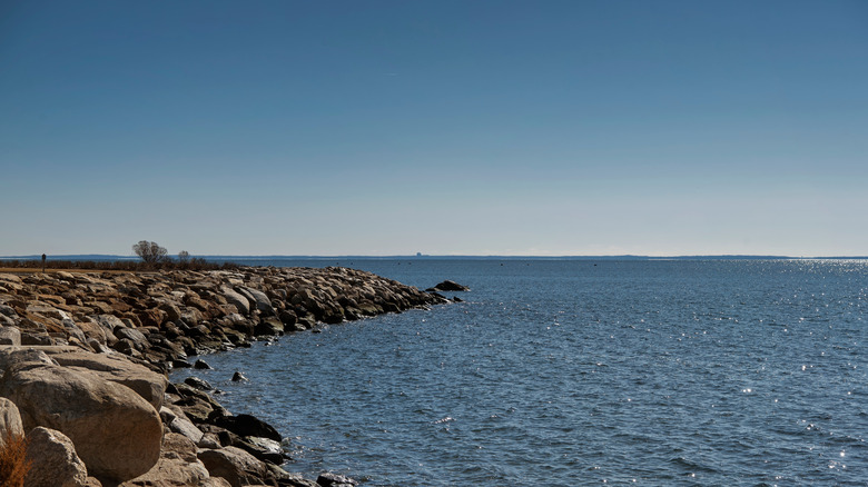 Vista de un embarcadero rocoso que se adentra en Long Island Sound en el Parque Estatal Sherwood Island