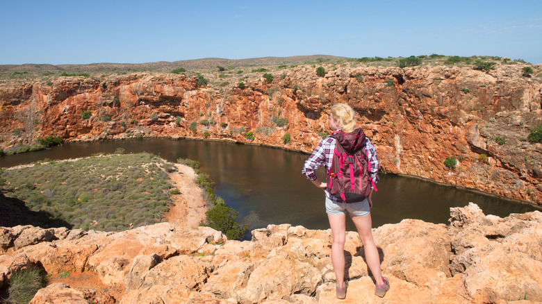 Mujer haciendo senderismo en el interior de Australia, con vistas al río Yardie Creek en el Parque Nacional Cape Range
