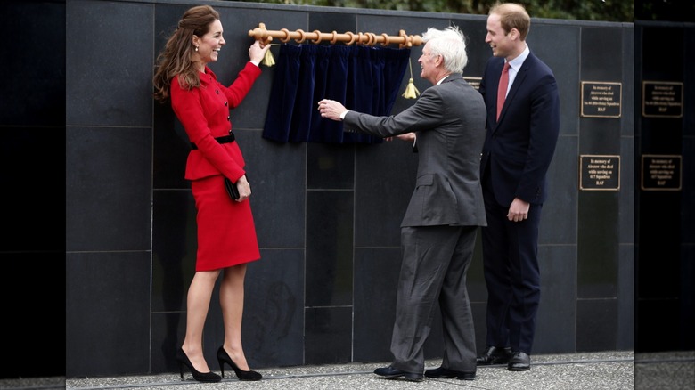 Catalina, duquesa de Cambridge y el príncipe Guillermo, duque de Cambridge, se ríen mientras una cortina falla en el Museo de la Base Aérea de Wigram el 14 de abril de 2014 en Christchurch, Nueva Zelanda (2014)