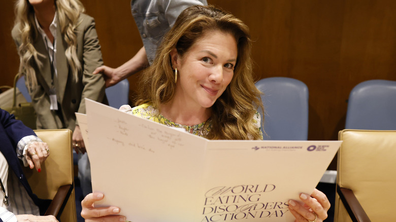 Sophie Grégoire Trudeau sonriendo mientras sostiene una carpeta