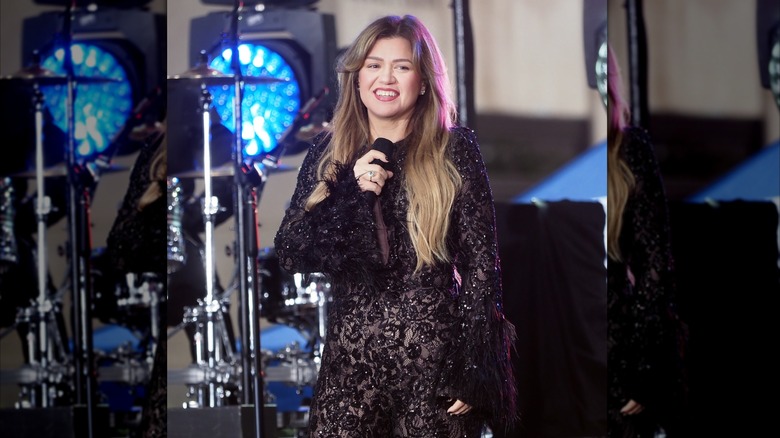 Kelly Clarkson cantando en el escenario con un mono