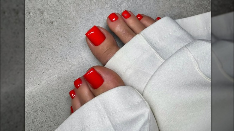 Pedicura con esmalte de uñas rojo brillante.