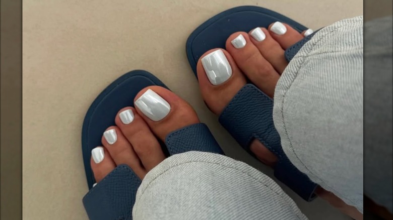 Una pedicura con esmalte de uñas cromado plateado.