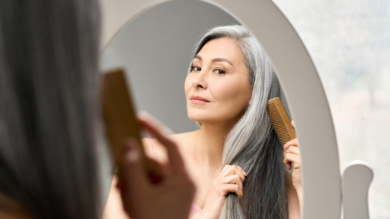 Mujer cepillándose el cabello con un peine
