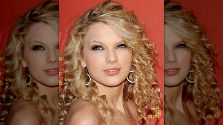 Taylor Swift con aros, ojos ahumados y labios nude en un evento de alfombra roja en 2007.