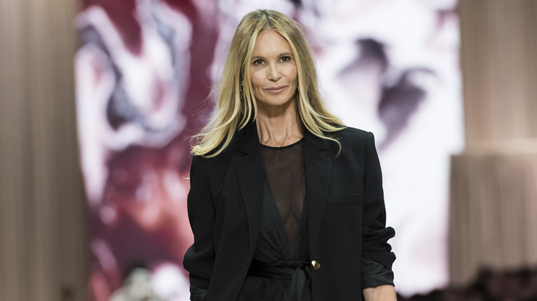 Elle MacPherson camina por la pasarela con un vestido negro transparente combinado con una chaqueta extragrande
