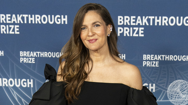 Drew Barrymore le da una suave sonrisa a la cámara durante una sesión fotográfica en la alfombra roja