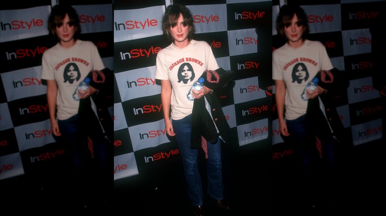 Winona Ryder posando en un evento luciendo jeans y camiseta.