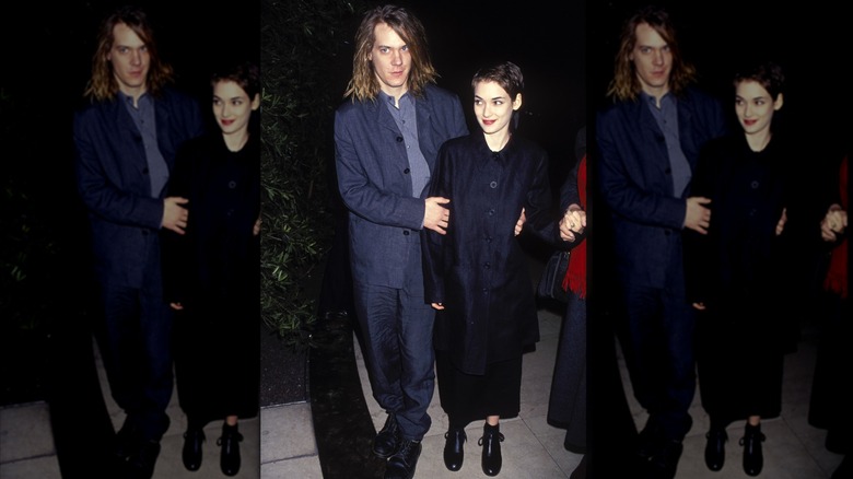 Winona Ryder y Dave Pirner vistiendo de negro y posando juntos en un evento.