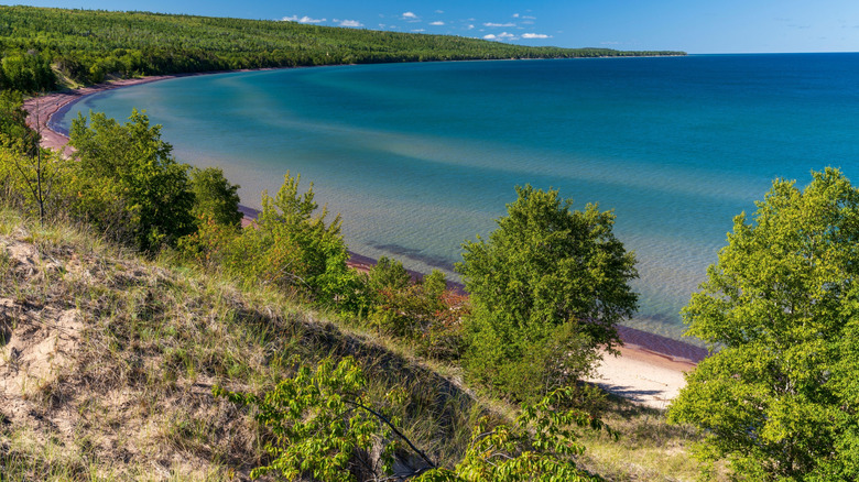 Una vista aérea de Mohawk, Michigan y el Lago Superior, que muestra árboles y agua clara.