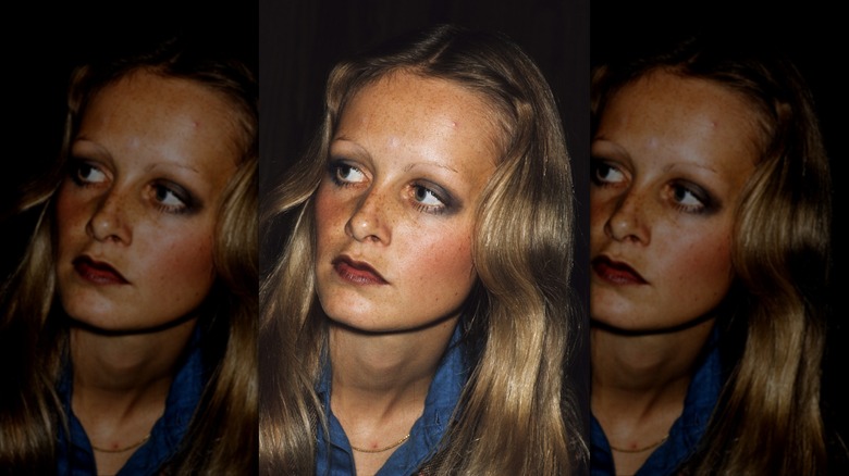 Twiggy mira hacia la izquierda con una camisa azul y maquillaje de ojos ahumado.