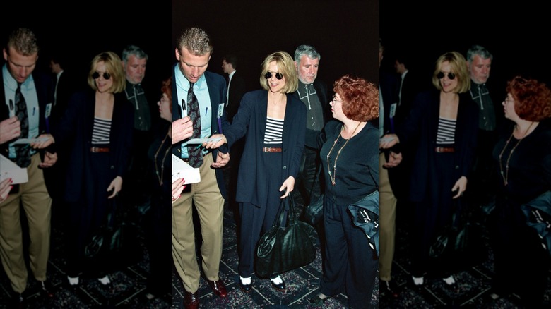 Meg Ryan se fotografió vistiendo un traje pantalón azul marino con una camisa a rayas y gafas de sol.