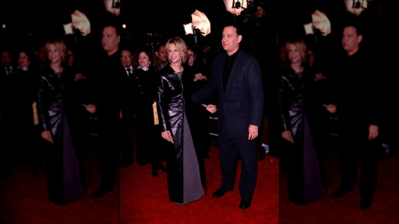 Meg Ryan con una chaqueta de cuero hasta el suelo junto a Tom Hanks en la alfombra roja.