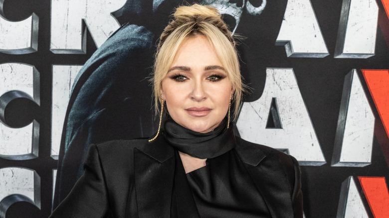 Hayden Panettiere posando en la alfombra roja con un blazer de satén negro