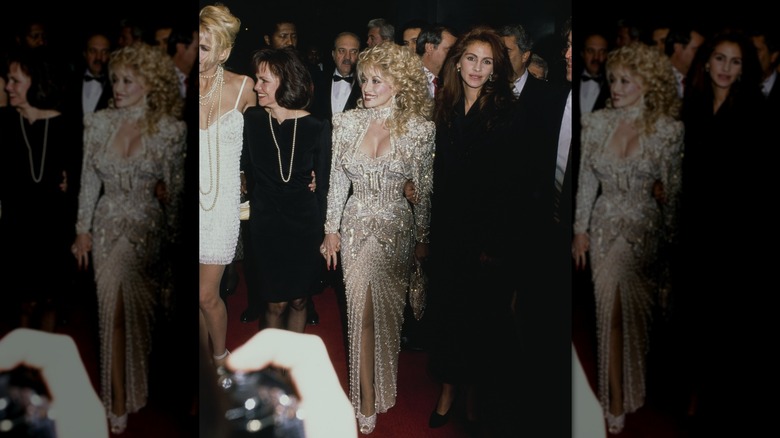Dolly Parton con un vestido blanco adornado y Julia Roberts con un vestido negro en la alfombra roja.