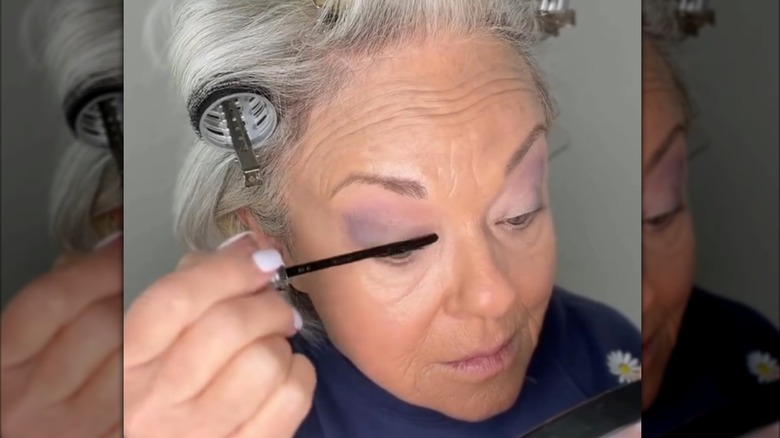 Mujer madura aplicando rímel