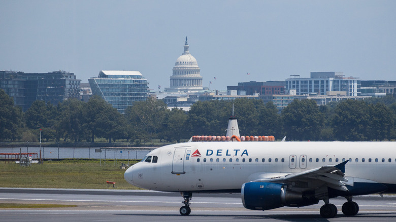 Vuelo de Delta en la pista del Aeropuerto Nacional Ronald Reagan de Washington (DCA) con el edificio del Capitolio al fondo