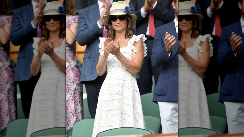 Pippa Middleton aplaudiendo con un vestido blanco con gafas de sol y un sombrero de fieltro en Wimbledon en 2018.