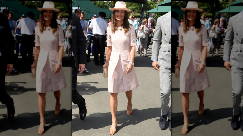 Pippa Middleton con un vestido rosa claro y un sombrero fedora caminando en Wimbledon en 2019.