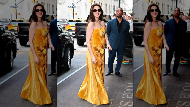 Anne Hathaway sonríe con un vestido amarillo sin tirantes
