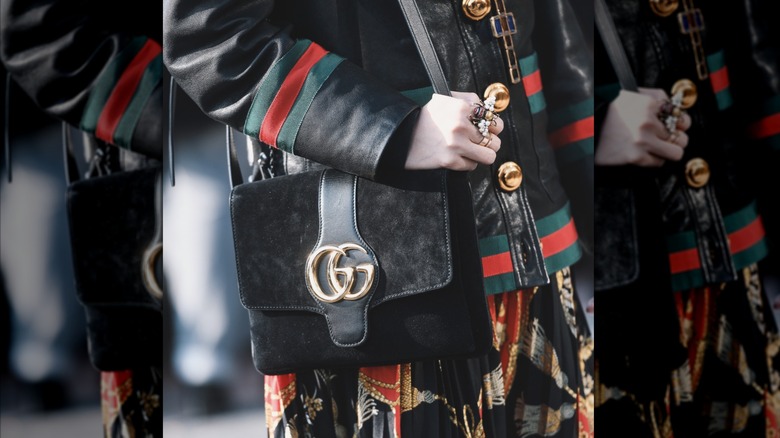 Una mujer que usa demasiados accesorios con artículos con logotipos llamativos.