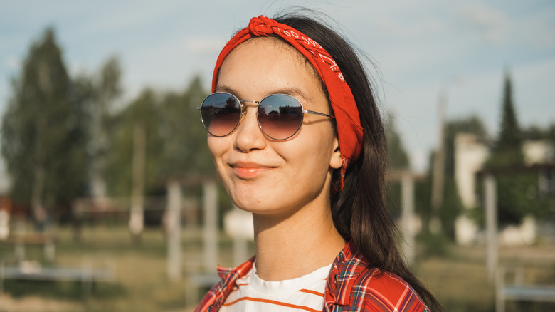 Una mujer con accesorios con gafas de sol y un pañuelo.