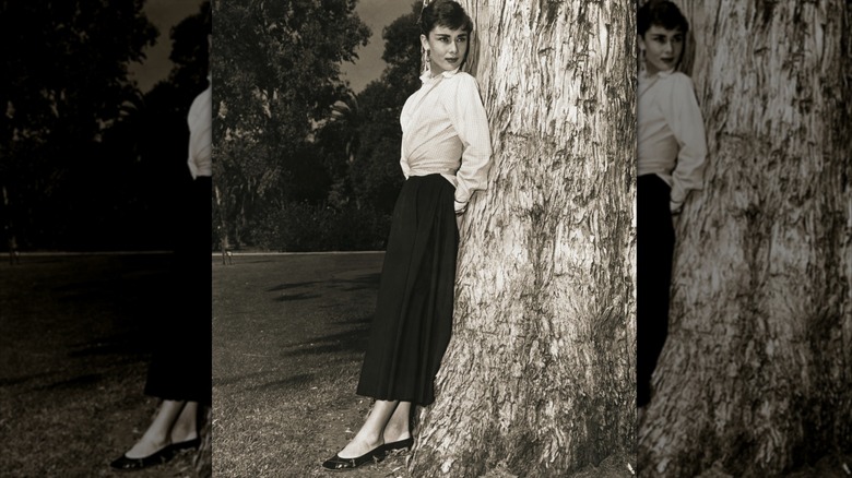 Audrey Hepburn frente a un árbol en los años 50