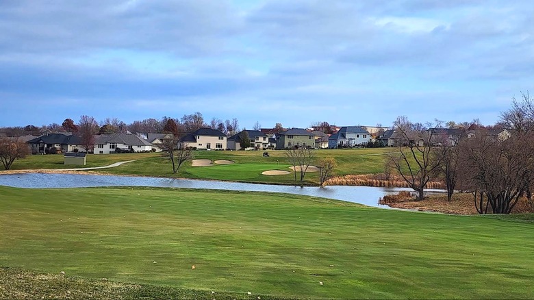 Césped, agua y edificios vistos desde The Legacy Golf Club, Norwalk, Iowa.