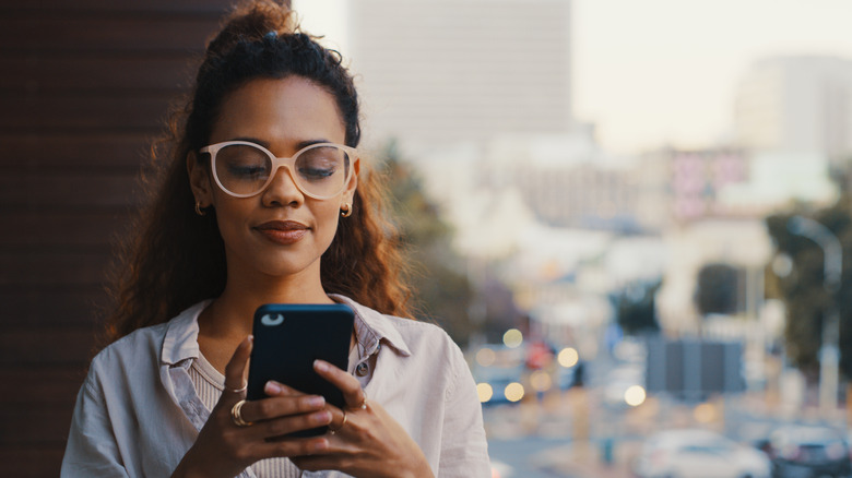 Una mujer enviando mensajes de texto en su teléfono inteligente
