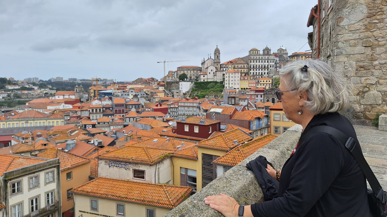 Una mujer jubilada mirando el horizonte de una ciudad portuguesa
