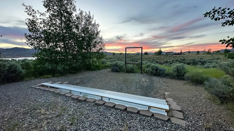 Una vista del atardecer en el área recreativa Wild Horse de Nevada presenta prados abiertos, un lago (a la izquierda) y colinas.