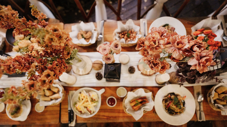 Mesa con comida y flores.