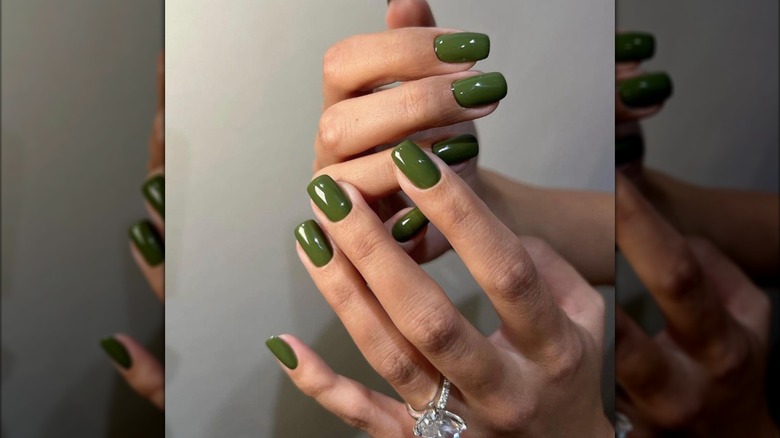 Manicura cuadrada corta con esmalte de uñas verde bosque.