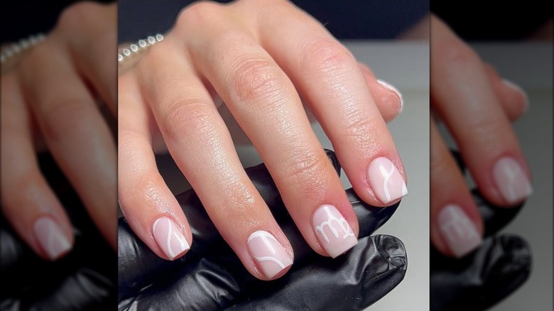 Manicura cuadrada corta con símbolo de Virgo pintado de blanco.