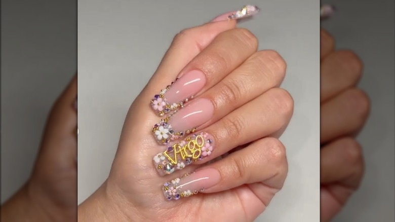 Manicura cuadrada con calcomanías florales y la palabra. 