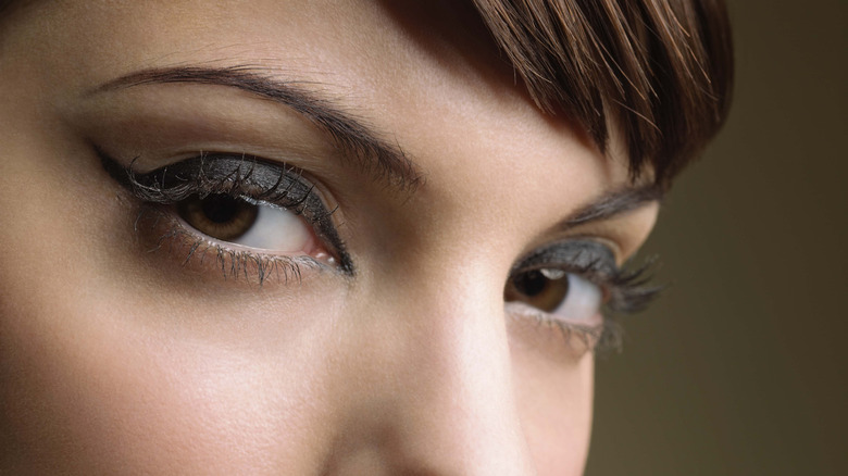 Primer plano de los ojos de una mujer, enmarcados por un delineador de ojos oscuro, mirando a la cámara.