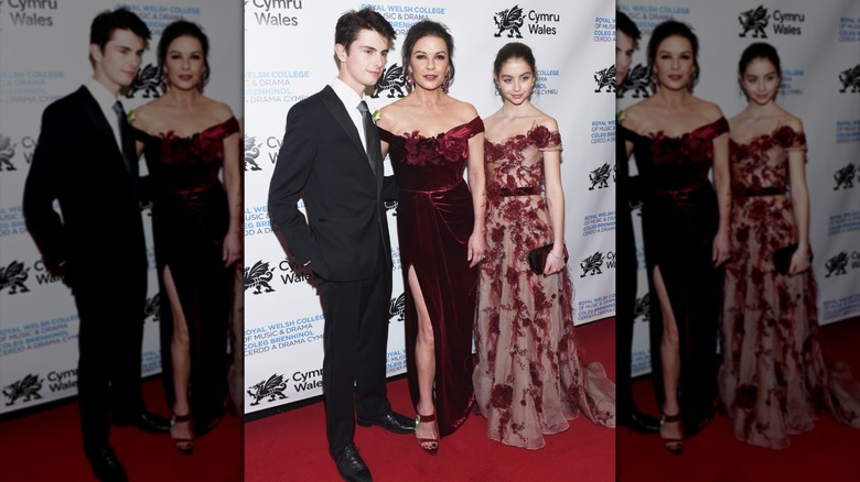 Carys Douglas con un vestido rojo transparente con Catherine Zeta Jones y Dylan Douglas