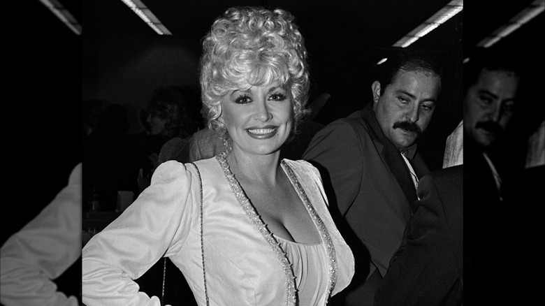 Dolly Parton en 1984 vistiendo un traje blanco.