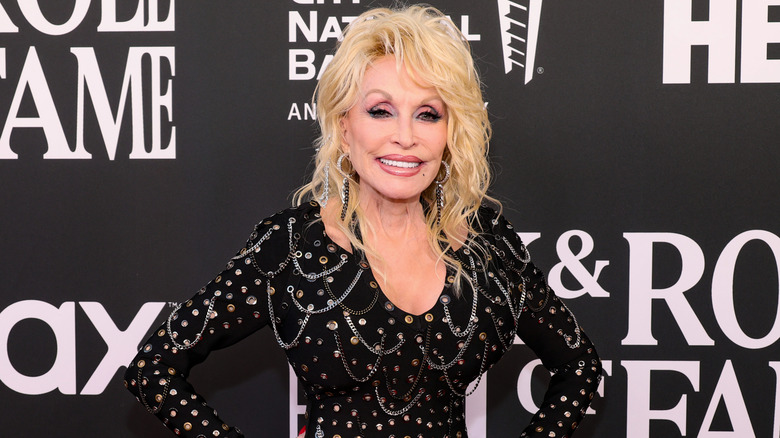 Dolly Parton con un vestido negro y una gran cabellera al estilo de los 80