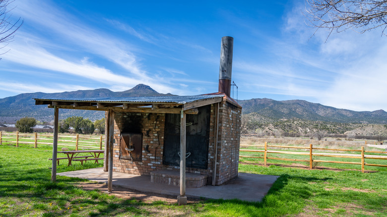 Una antigua estructura en el Parque Estatal Rockin' River Ranch, Arizona, cerca del río Verde, con un fondo montañoso