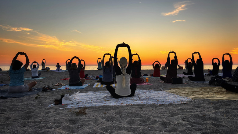 Gente haciendo yoga en la playa al amanecer en Englewood Beach, Florida