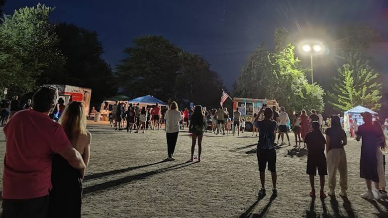 Personas disfrutando de una noche de fiesta en un evento comunitario en un parque en Sharon, MA