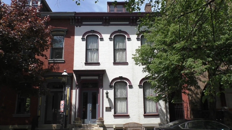 Lugar de nacimiento de Gertrude Stein, una casa adosada de dos pisos pintada de blanco con una puerta azul y detalles en granate, y un banco de madera en el frente