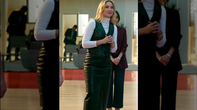 Kate Hudson con un conjunto de chaleco y falda de cuero con un jersey de cuello alto blanco debajo