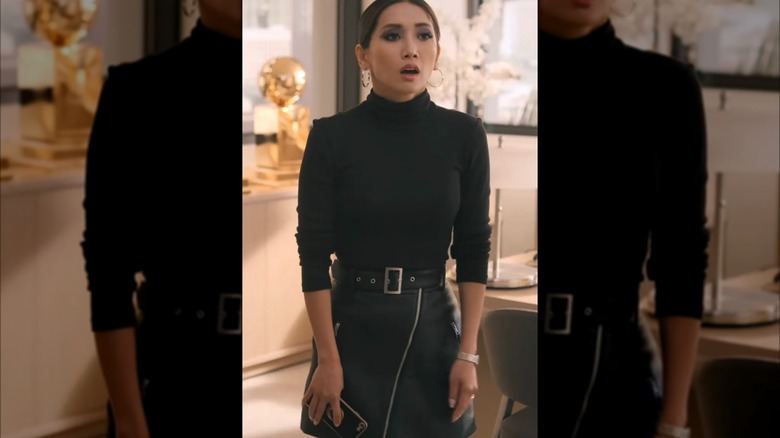 Brenda Song con un jersey de cuello alto negro y una falda de cuero negra