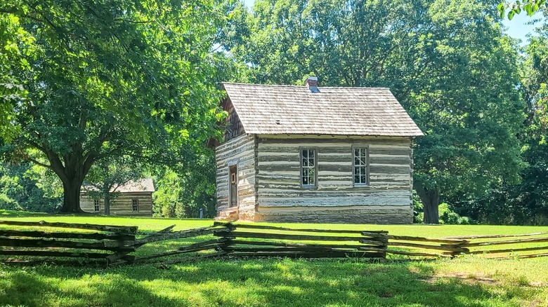 Una cabaña de madera rodeada de árboles en Prairie Grove Battlefield State Park, Arkansas