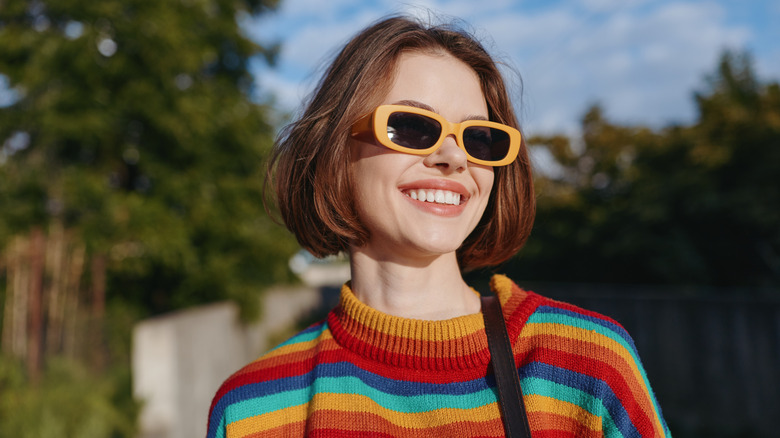 Una mujer con gafas de sol y un bob rojo y contundente.