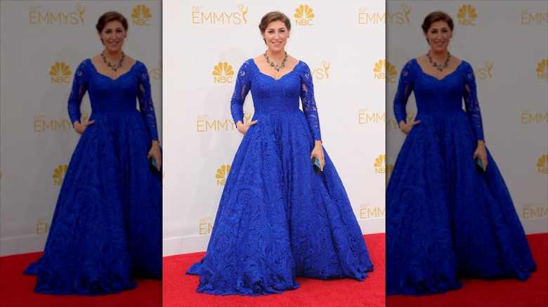 Mayim Bialik posa en la alfombra roja con un vestido de fiesta azul cobalto de manga larga.