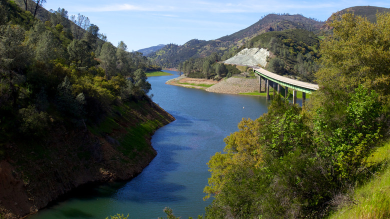 Carretera y puente que cruza el lago McClure, rodeado de colinas